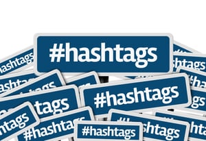Hashtags written on multiple blue road sign